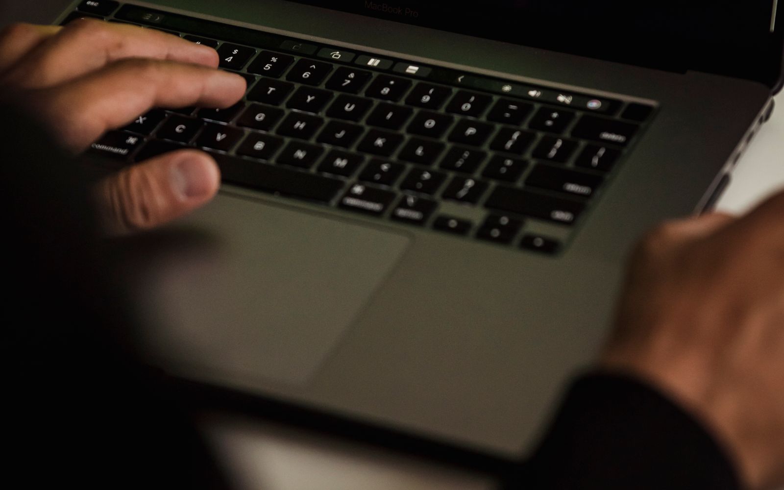 Security tester working at a laptop with technical data during an offensive-security assessment.