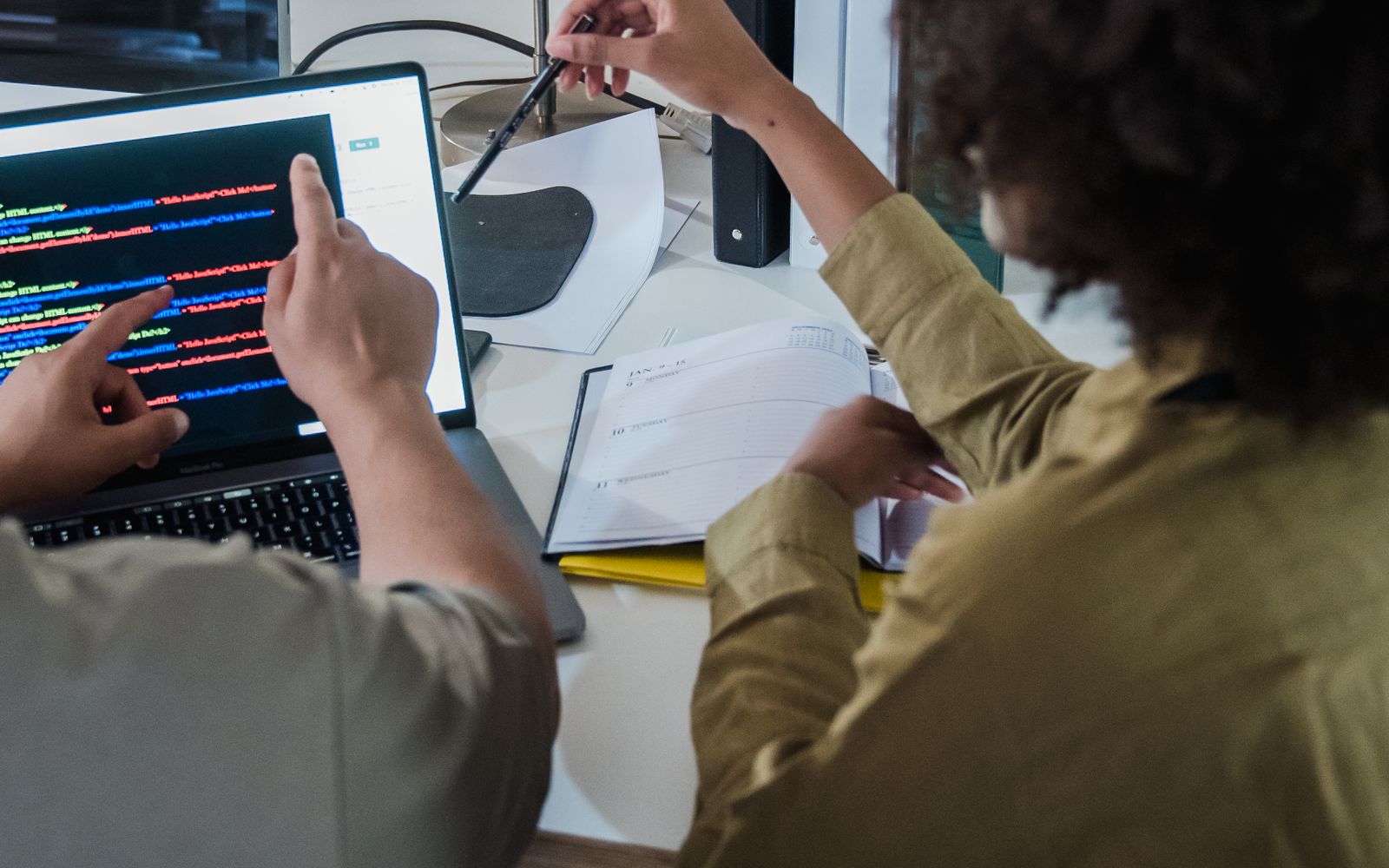 Software development team collaborating on code in a modern office, representing software, automation and applied AI engineering work.